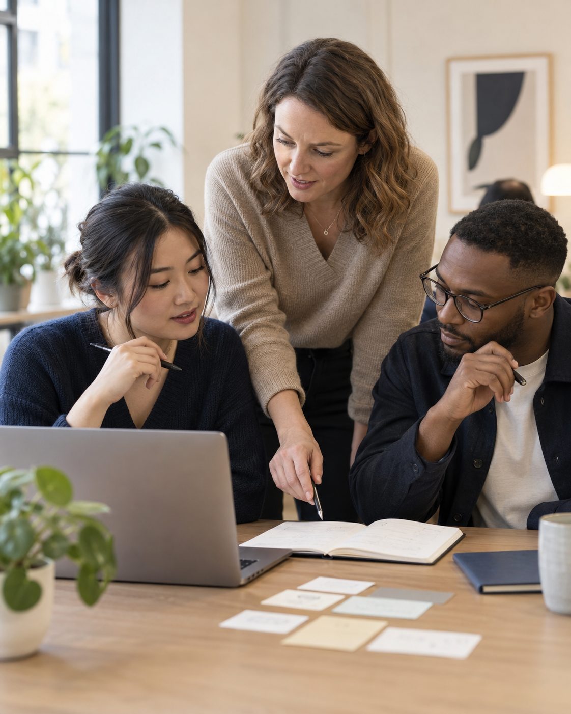 A facilitator leading a small team through material on a laptop